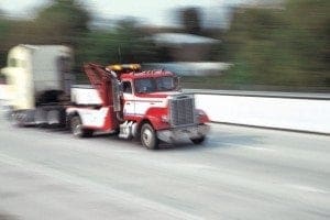 Cab of semi truck being towed down highway